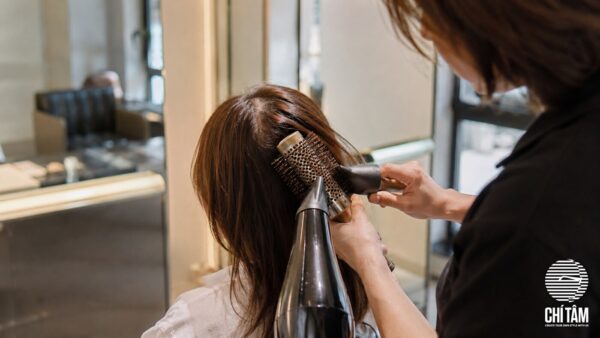 Stylist sấy ngược nâng phồng chân tóc cho khách tại Chí Tâm Hair Salon