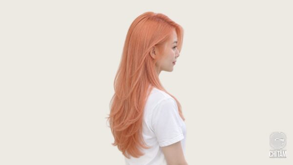 Tóc cam đào pastel nghiêng profile, màu lên đều từ chân tóc - Chí Tâm Hair Salon